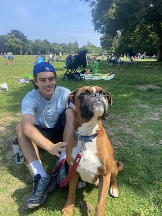 Adam crouched beside Buddy on the grass in St Anne’s Park